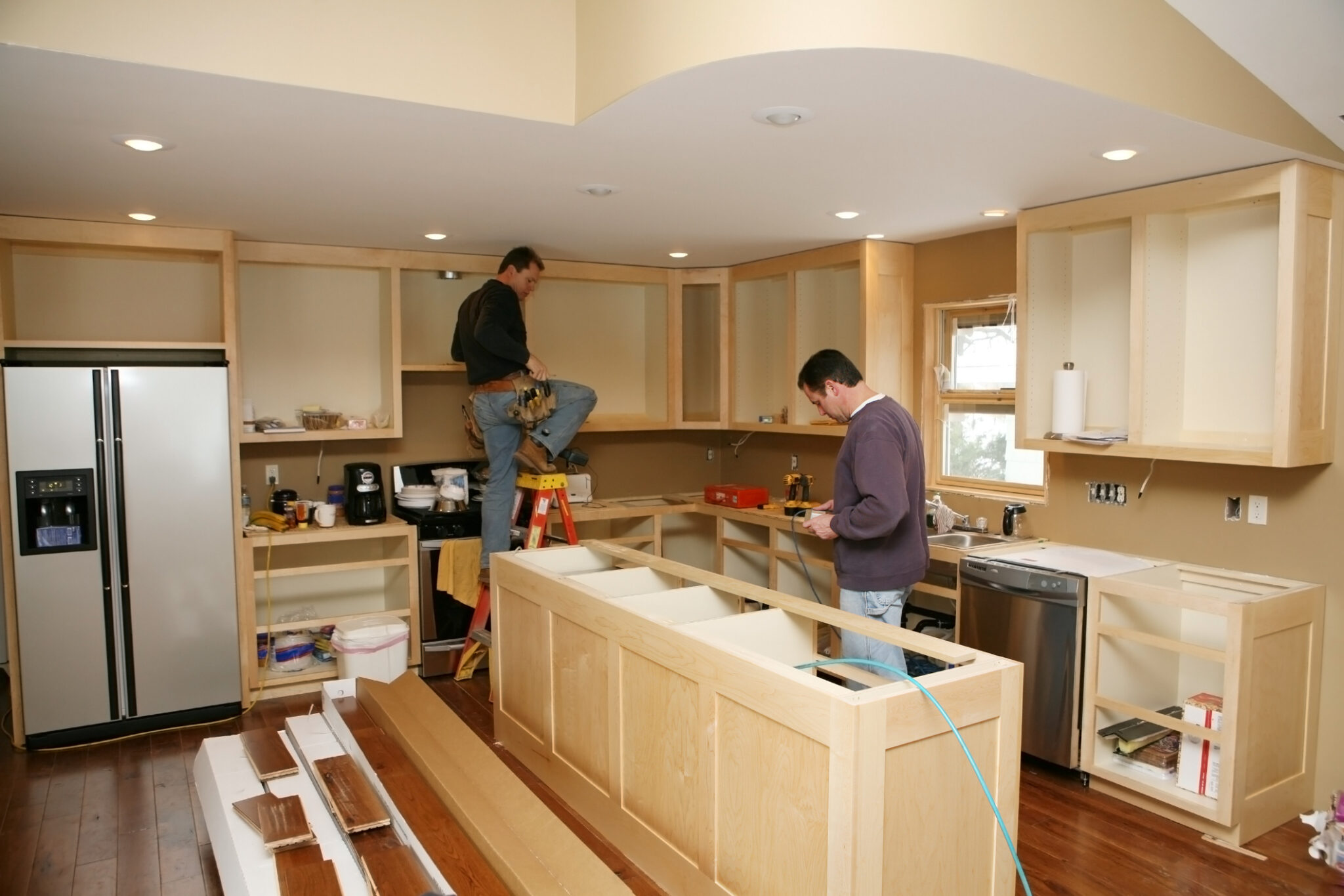Men working on kitchen cabinets installation.