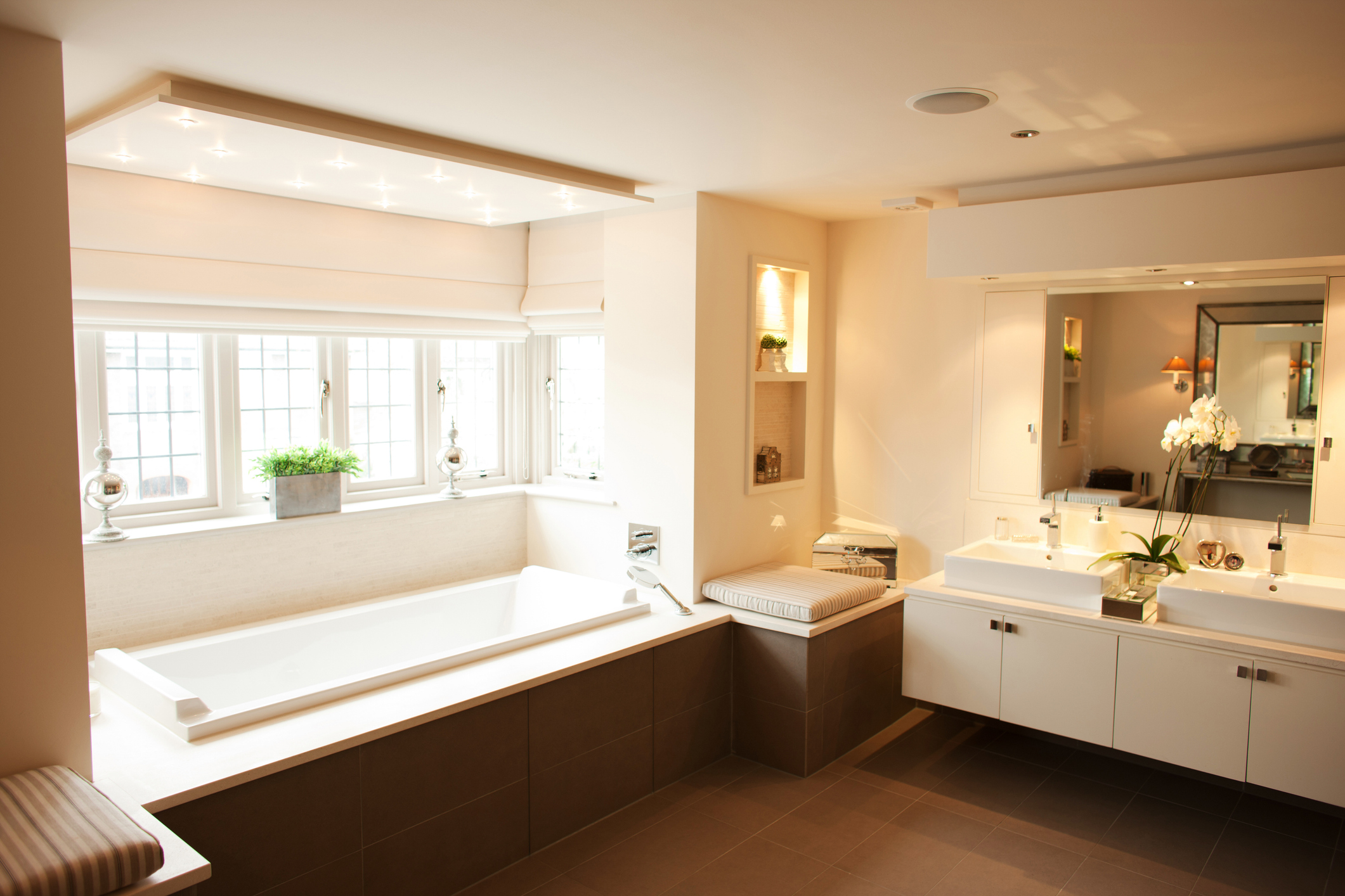 Modern bathroom with large bathtub and mirrors.