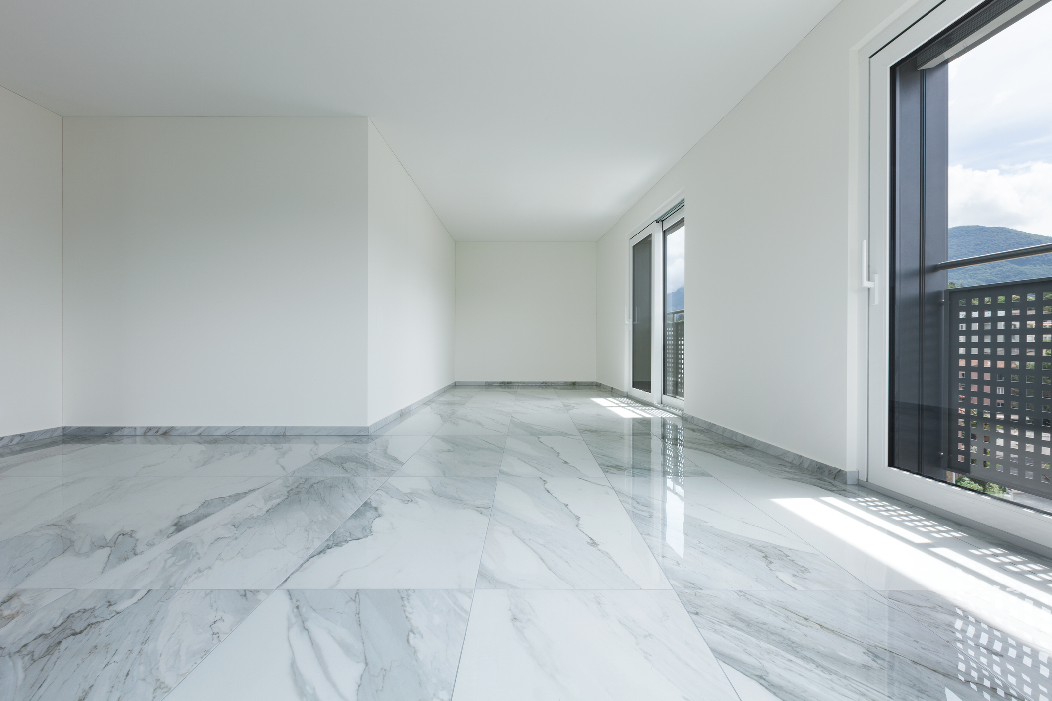 Empty room with marble floor and windows.