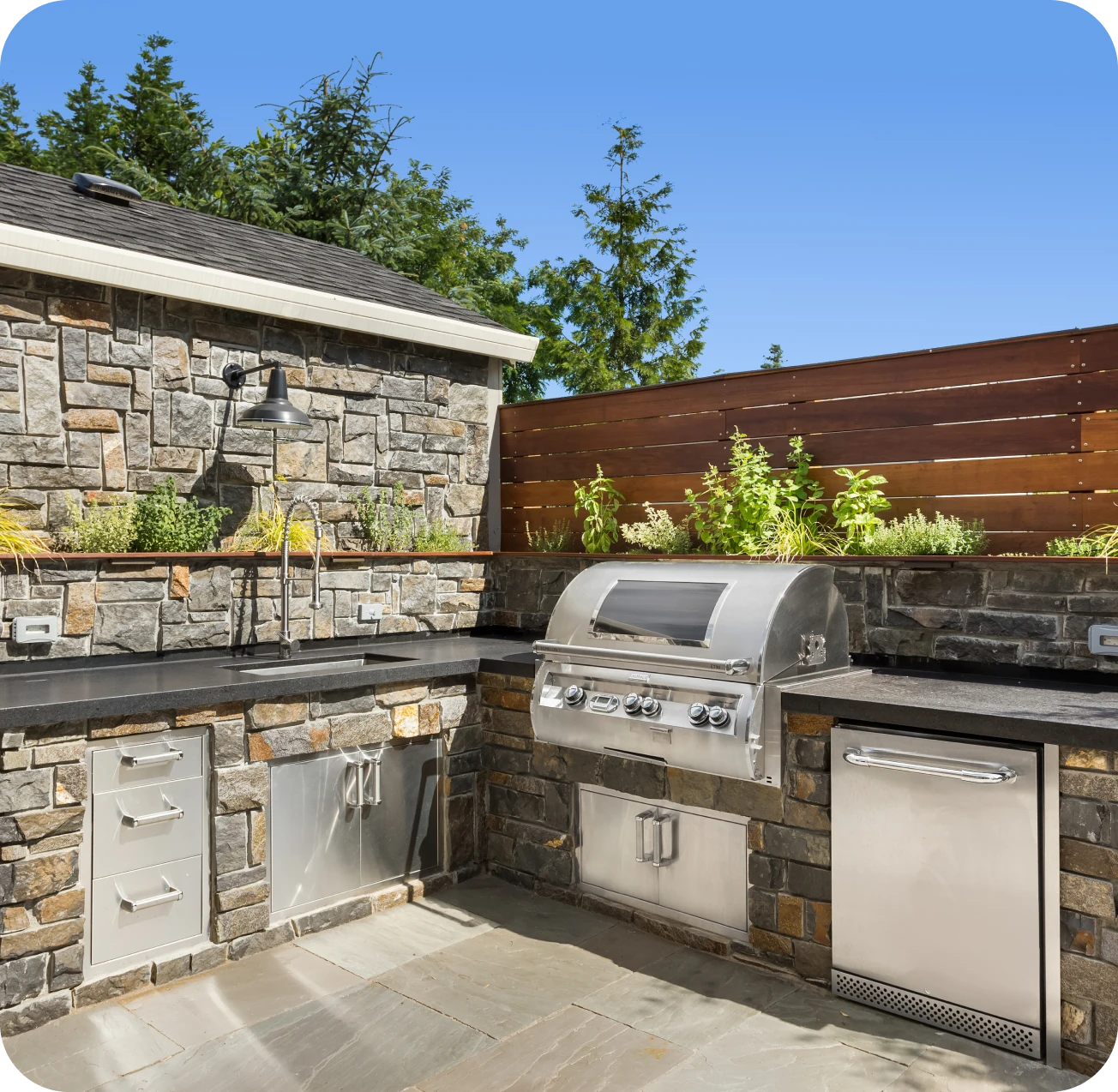 Outdoor kitchen with grill and stone countertops.